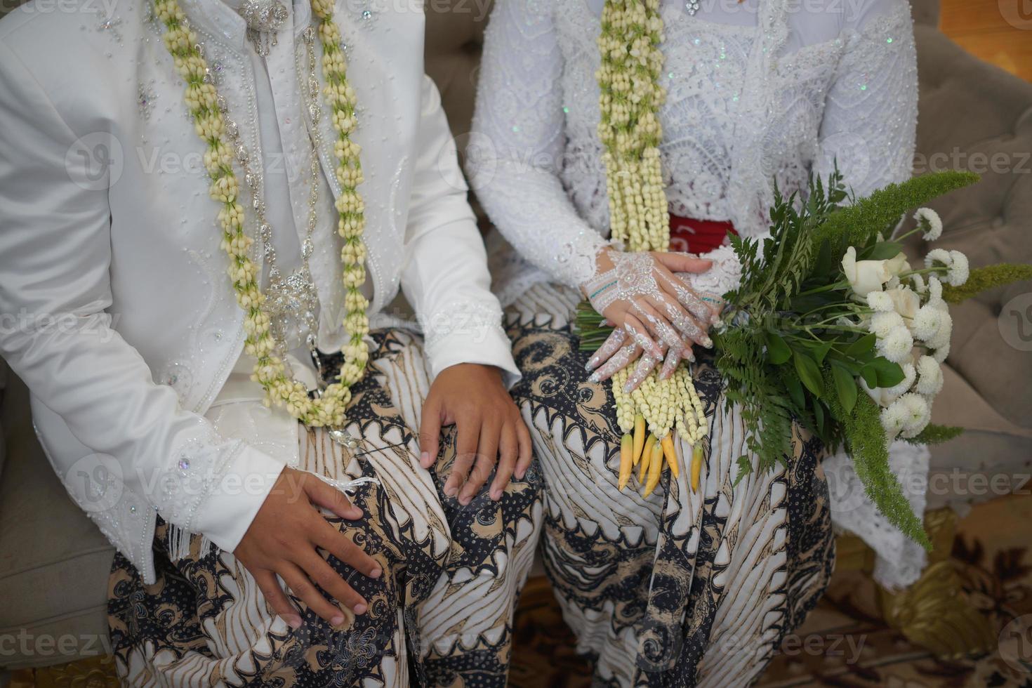 novio y novia en vestido de novia blanco con cubo de flores foto