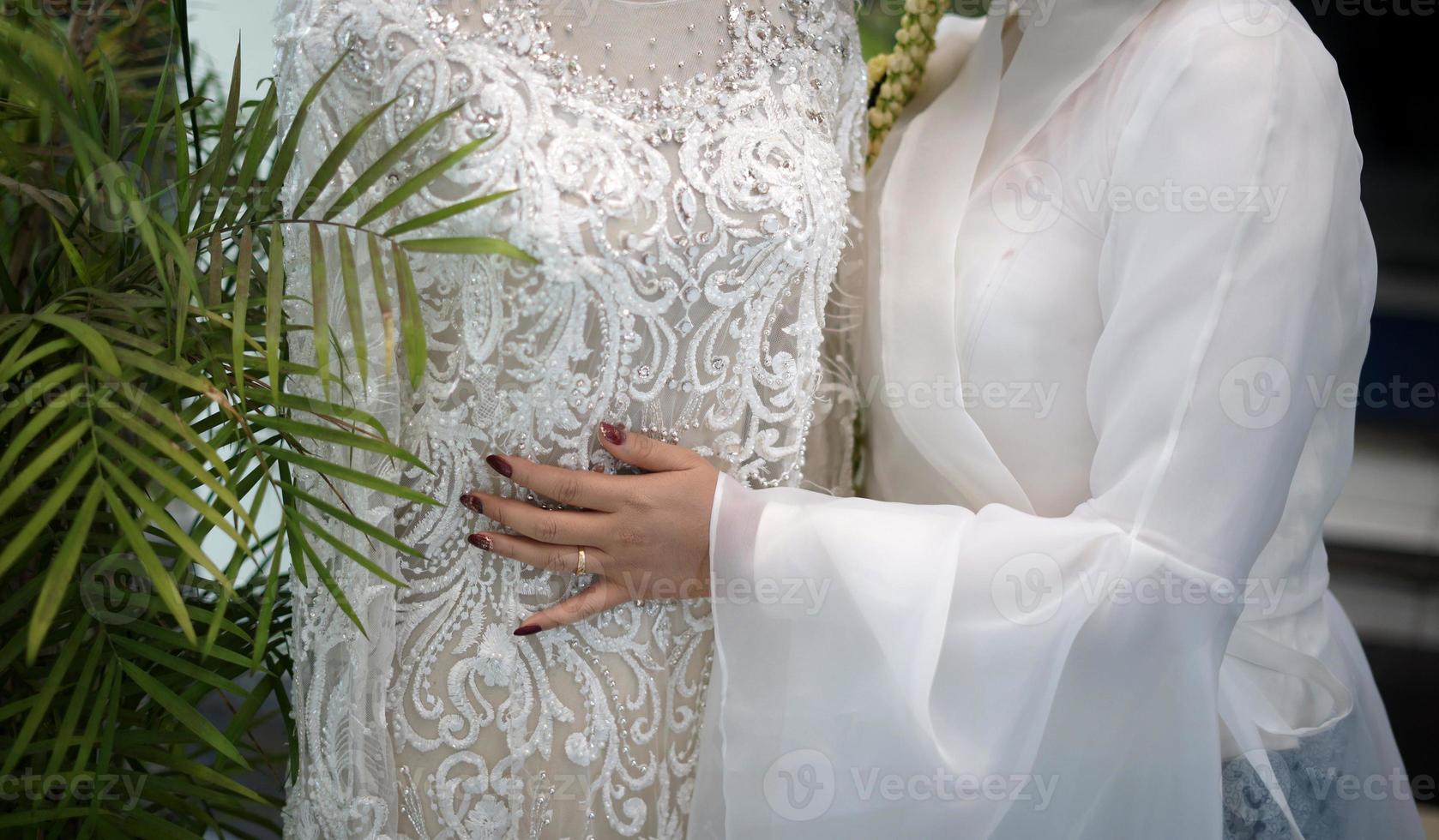 A Woman Hugging a White Wedding Dress on a Mannequin photo