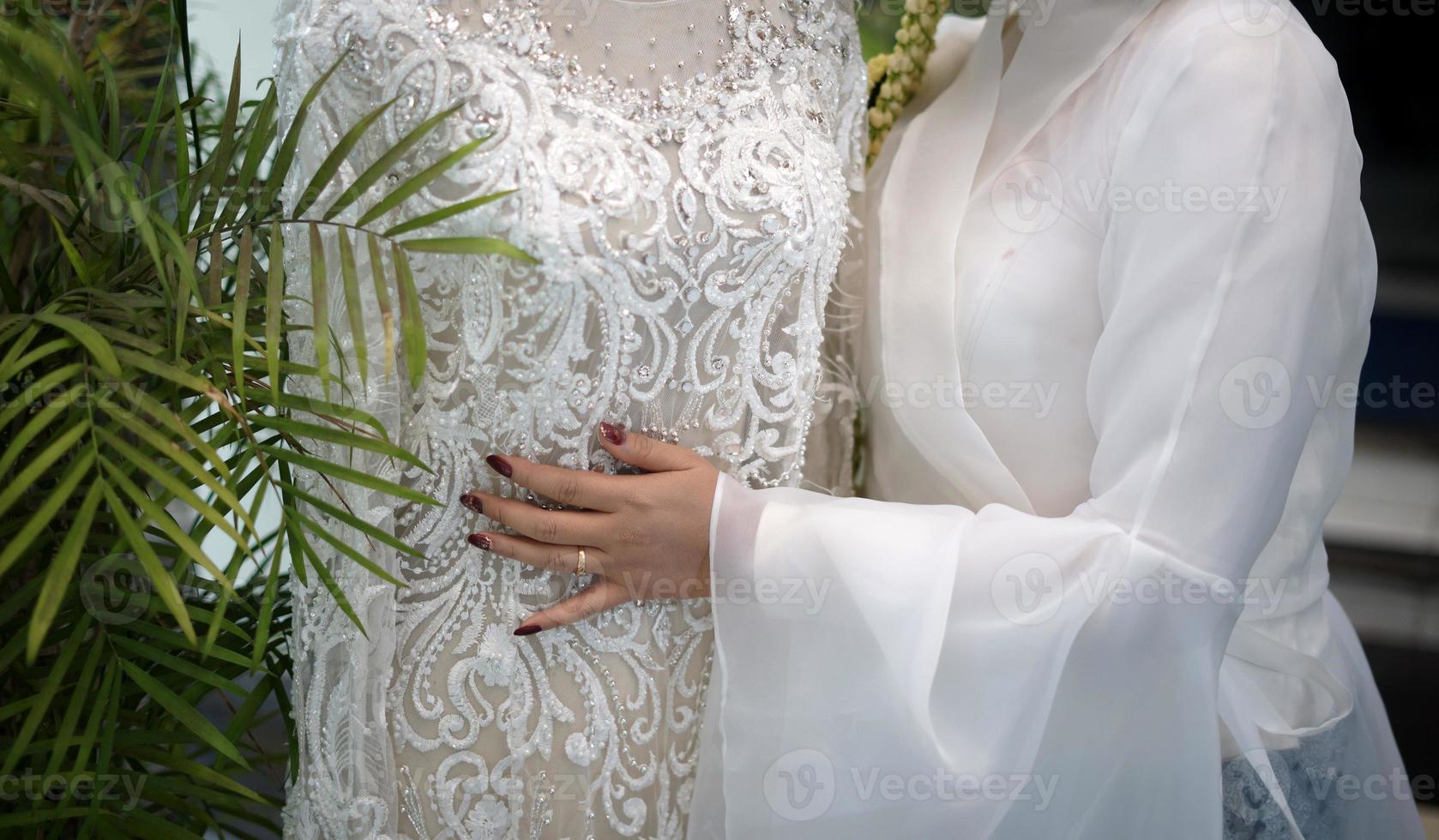 una mujer abrazando un vestido de novia blanco en un maniquí foto