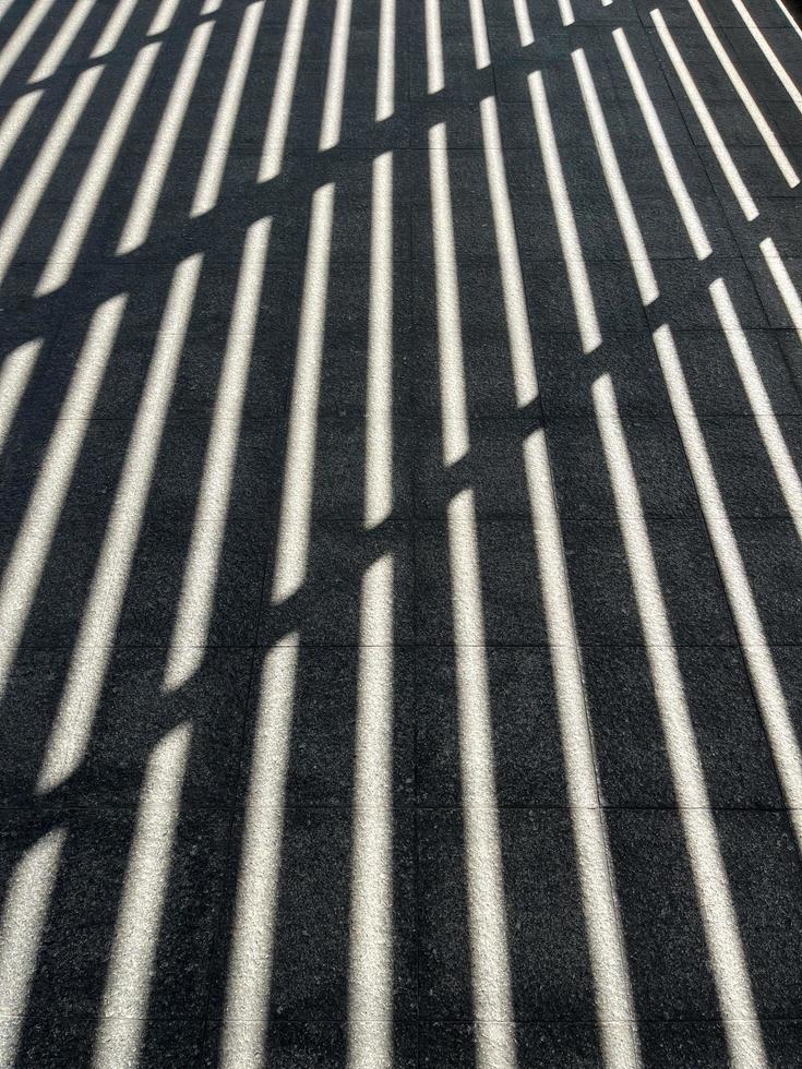 black and white shadow strips. a structural graphic shadow falling from the semi-open roof at noon. photo
