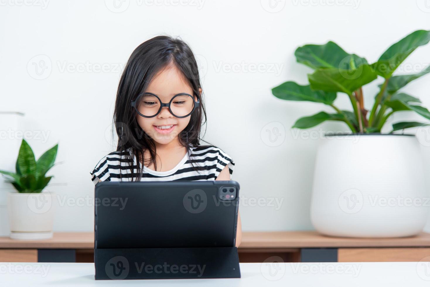 Asian child girl student wow excited on video call learning to studying online class or person learn from home school with tablet photo