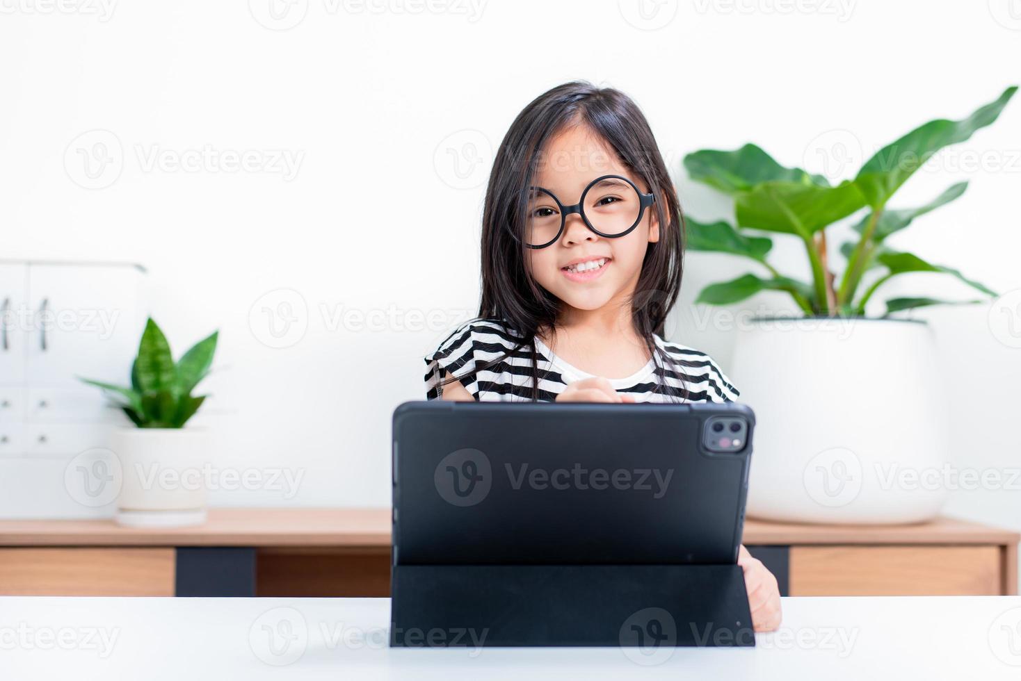 Asian child girl student wow excited on video call learning to studying online class or person learn from home school with tablet photo