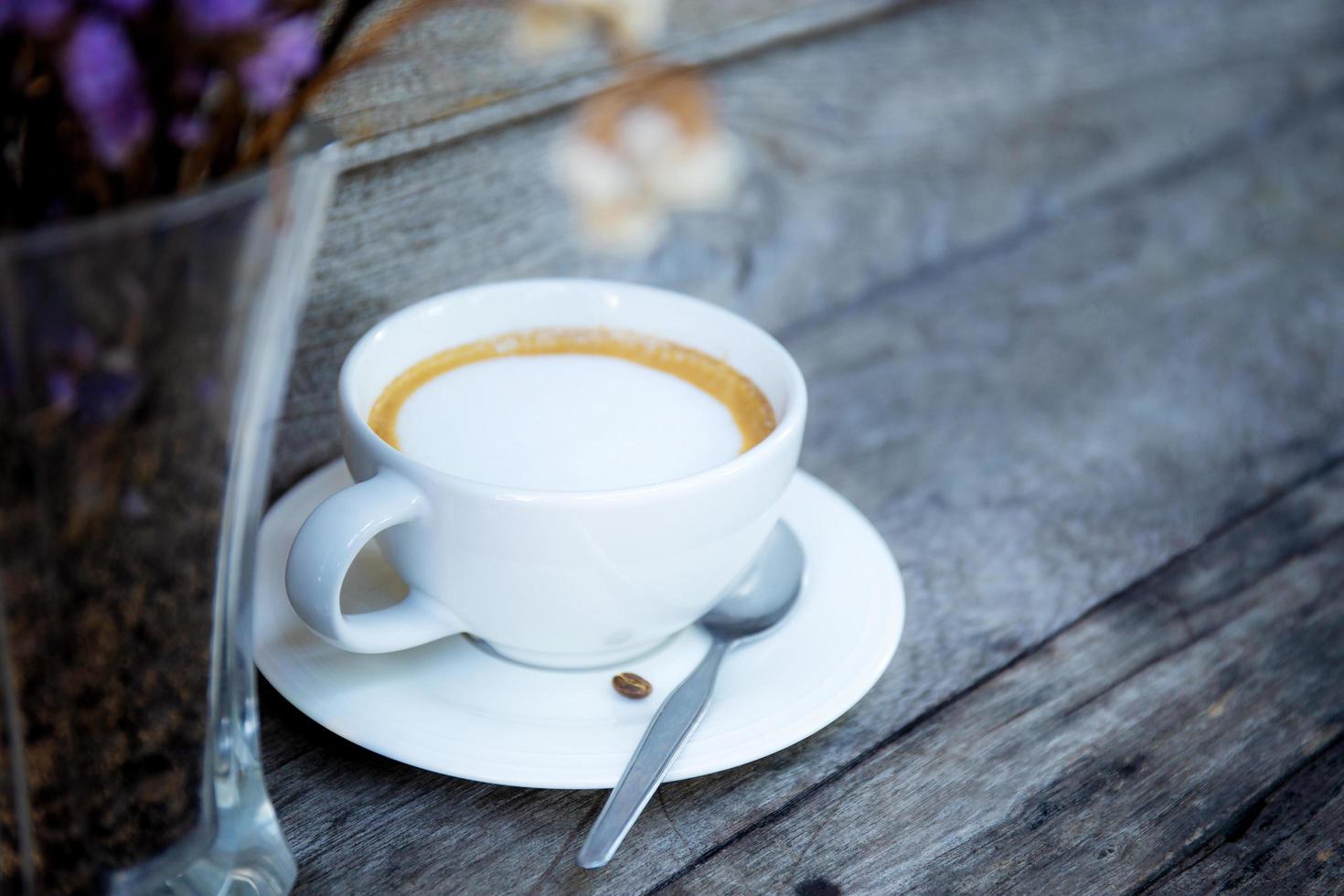 taza de café y jarrón en la mesa. foto