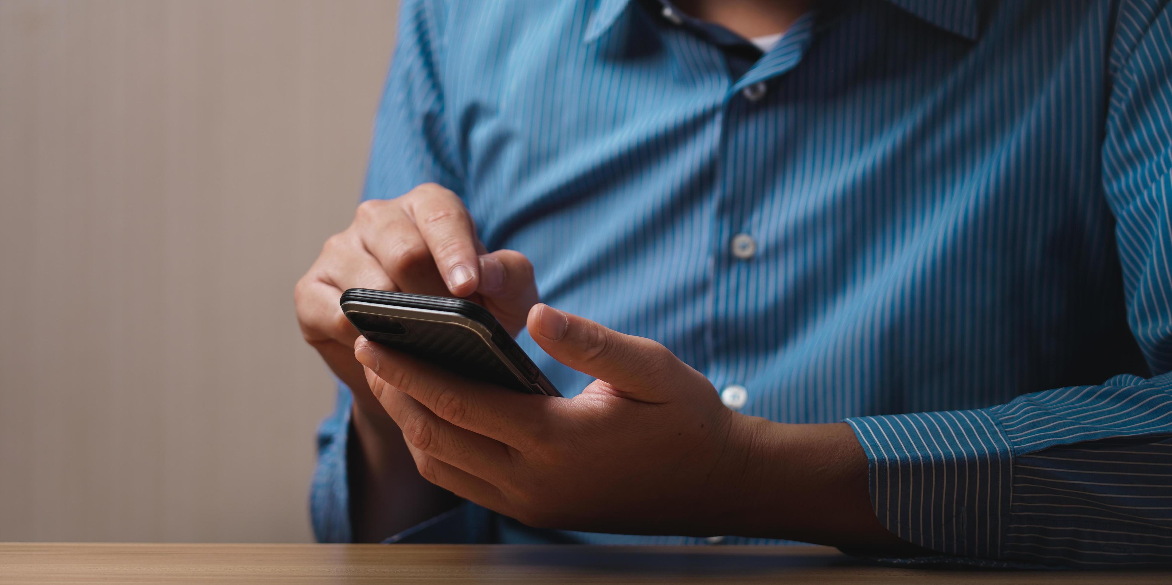 man's hand using a mobile phone browsing mobile device apps, reading