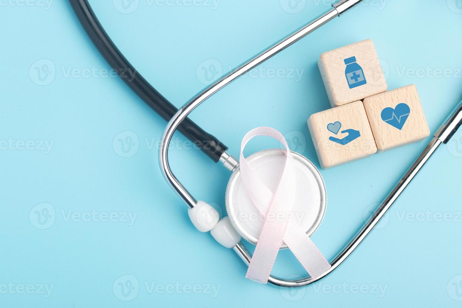 Pink ribbon and stethoscope. Breast cancer treatment concept. Copy space. photo