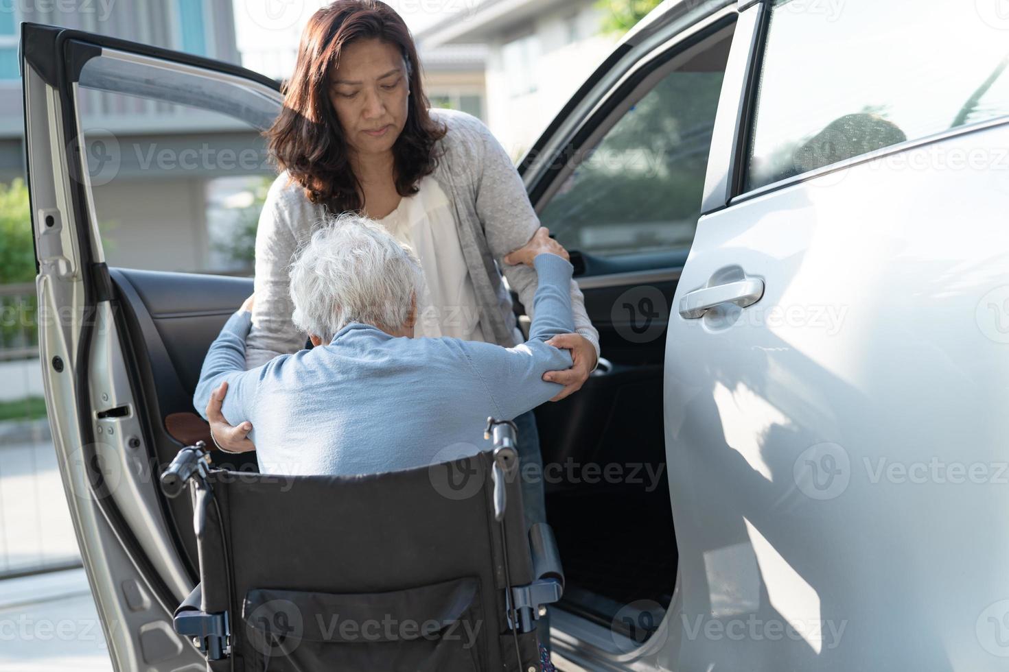 Asian senior or elderly old lady woman patient sitting on wheelchair prepare get to her car, healthy strong medical concept. photo