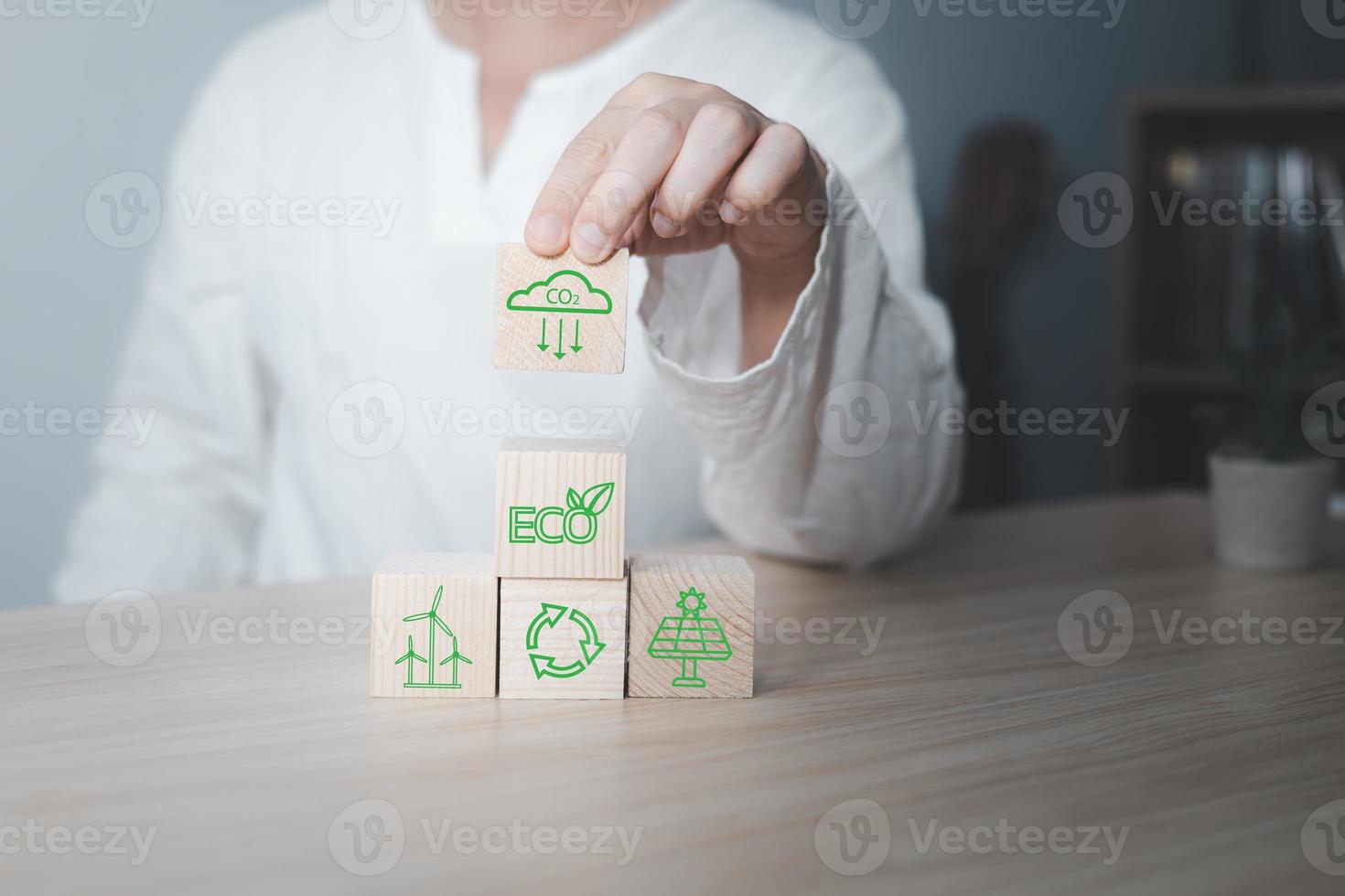 Hand of a businessman chooses reduce co2 icon on wood block circle.idea for environmentally conscious business, climate change, eco-friendly investment,ESG for Environment Social and Governance photo