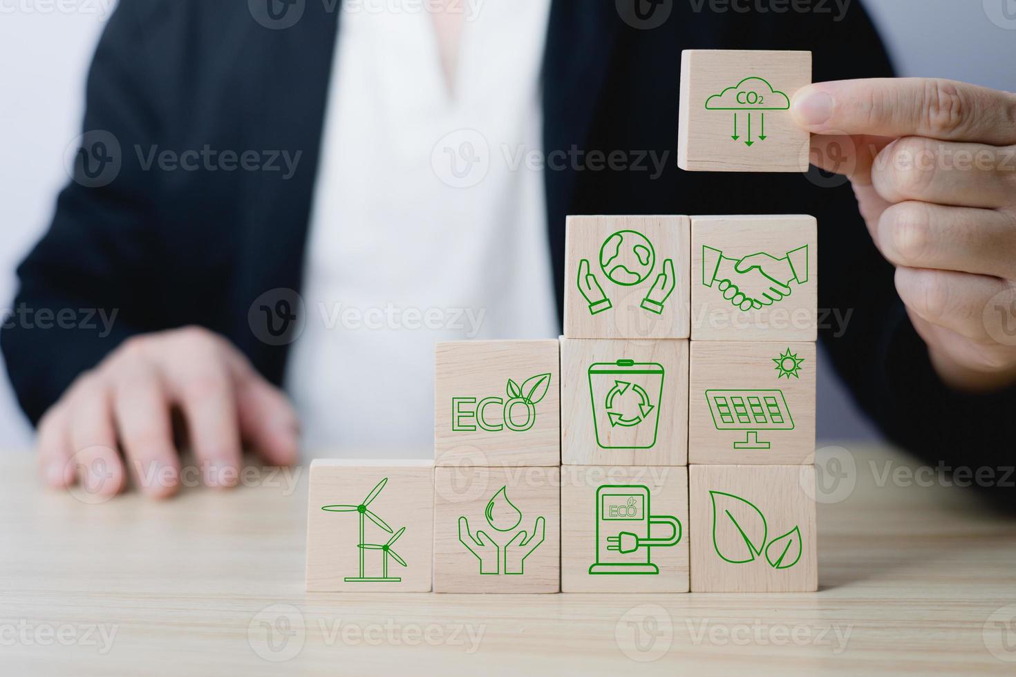 Hand of a businessman chooses reduce co2 icon on wood block circle.idea for environmentally conscious business, climate change, eco-friendly investment,ESG for Environment Social and Governance photo