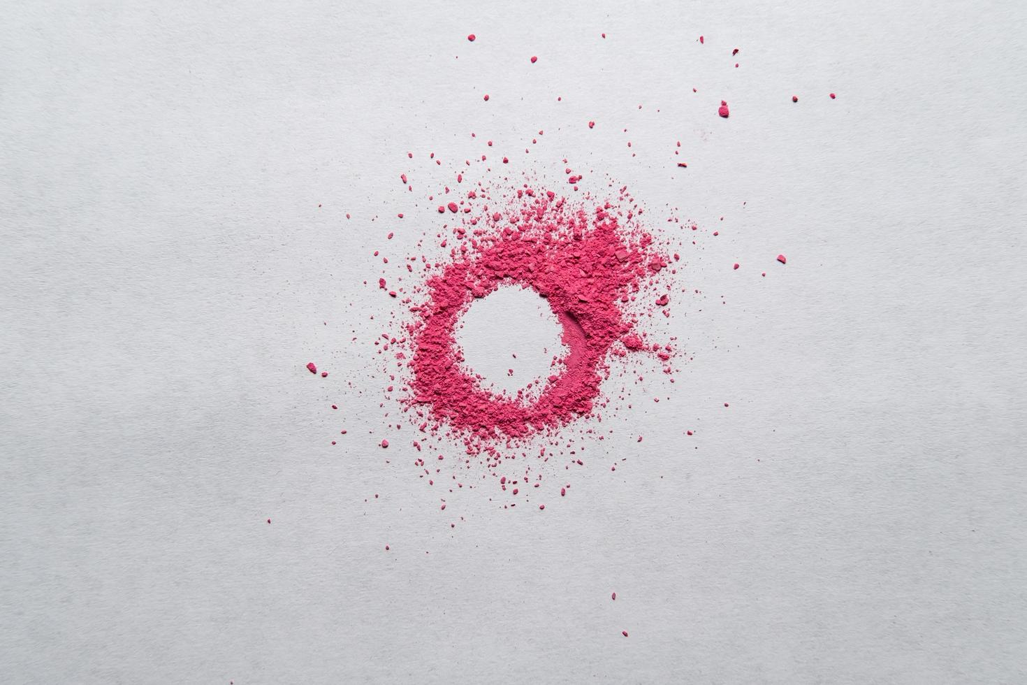 Circle made of red powder on a white background. Copy space. Dry paint with bright color. Top view. photo