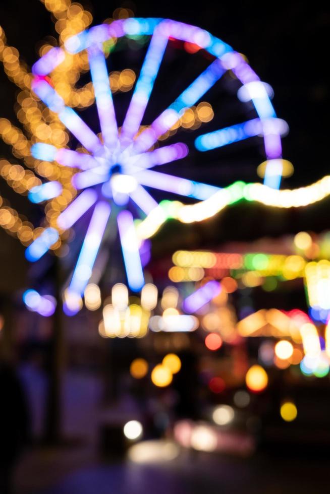 hermosas luces de colores borrosas y desenfocadas de una guirnalda en un carrusel. Feria navideña. foto