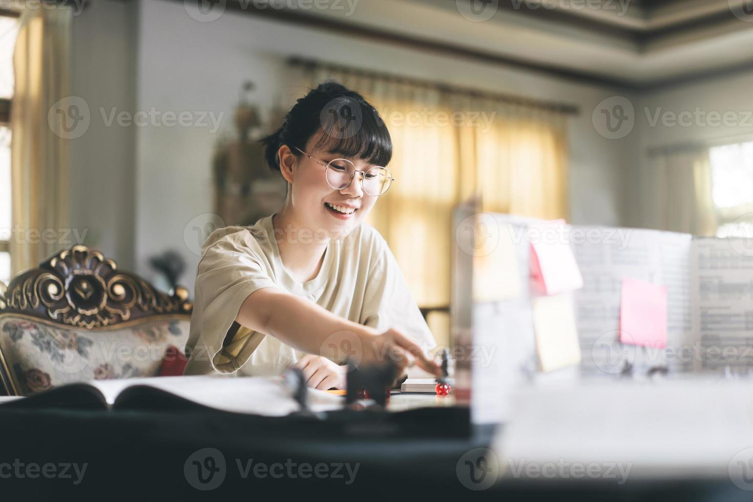 mujer asiática adulta joven que disfruta de juegos de rol narración de cuentos de mesa y juego de mesa con miniaturas foto