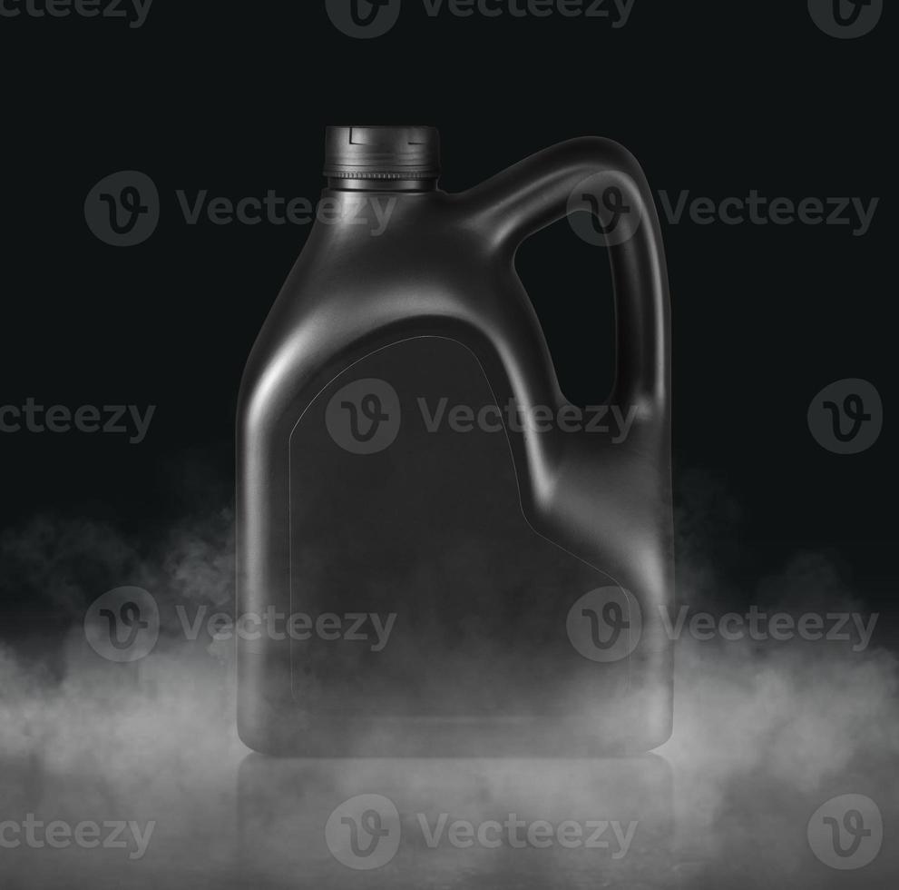 recipiente de plástico para aceite de máquina con vapor frío y fondo de estudio oscuro aislado foto