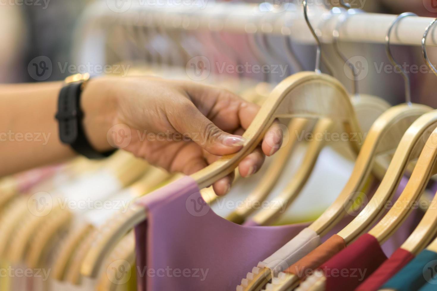 Clothes that are arranged on shelves and hangers photo