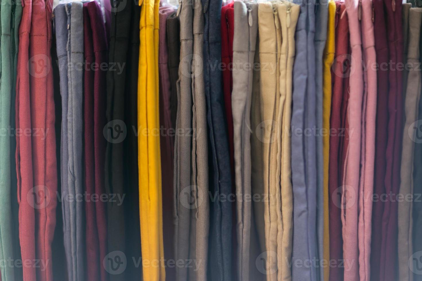Clothes that are arranged on shelves and hangers photo