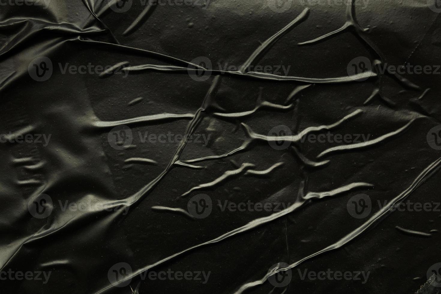 black crumpled and creased plastic poster texture background photo