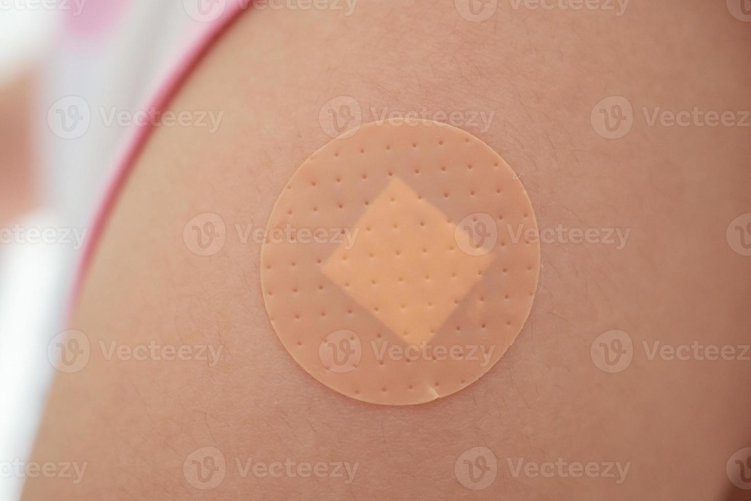 Vaccinated little asian girl with adhesive plaster after vaccine injection photo