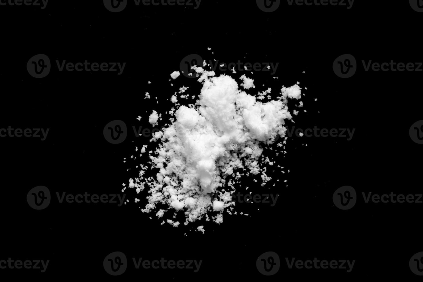 White snow isolated on black background close up photo