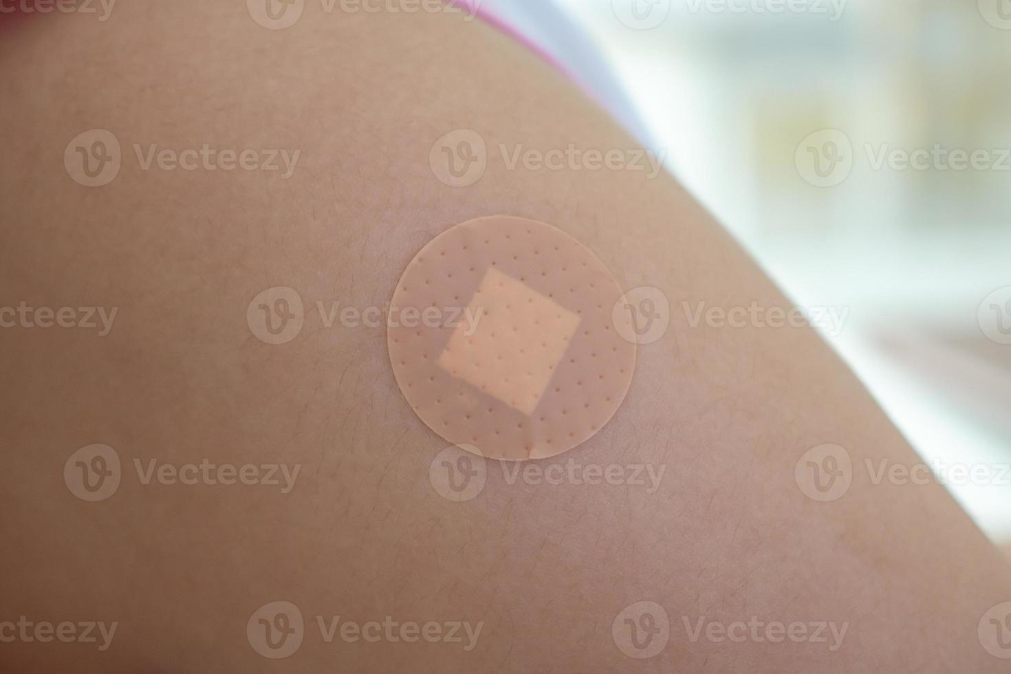 Vaccinated little asian girl with adhesive plaster after vaccine injection photo