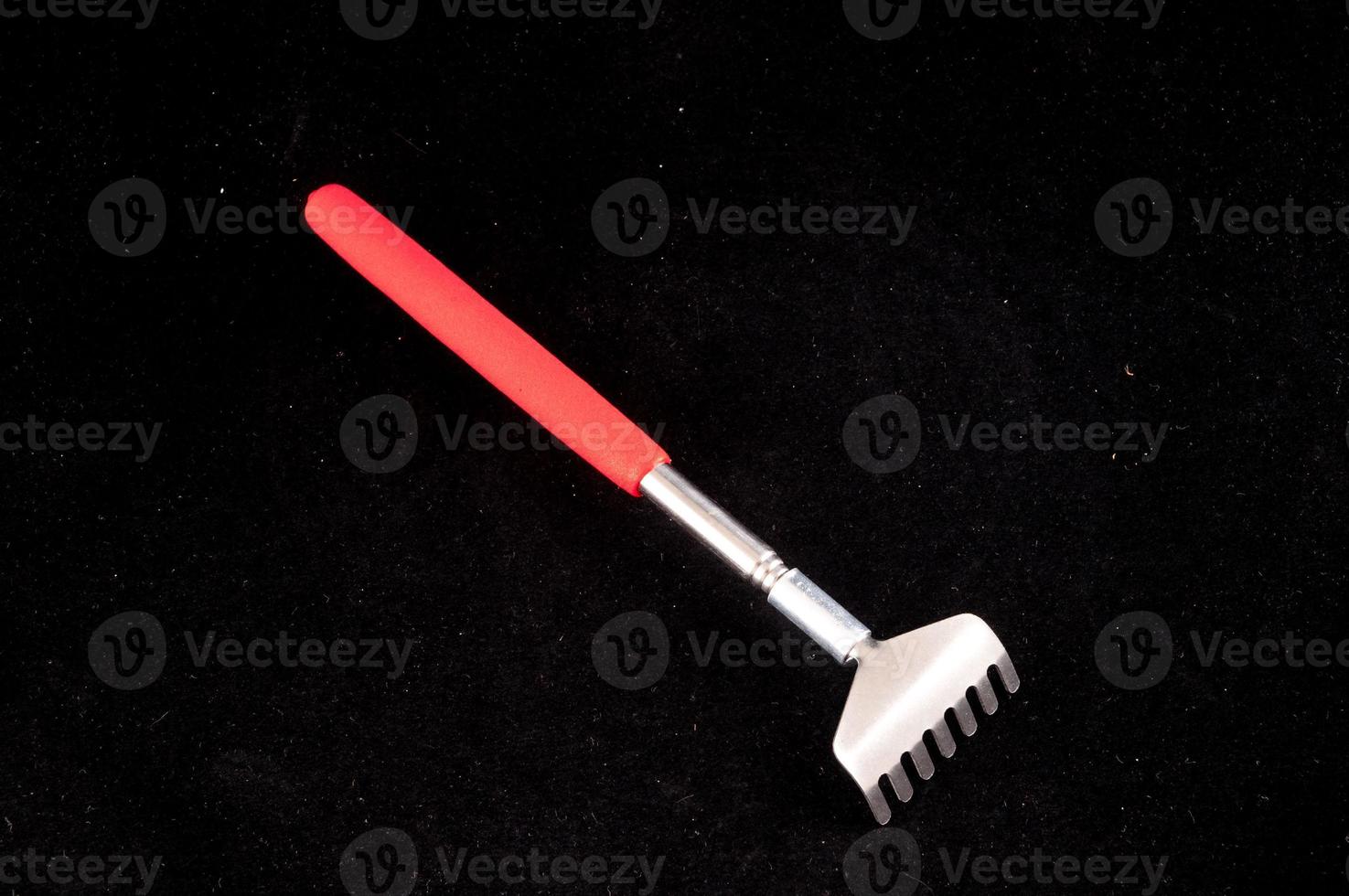 Mini rake on black background photo