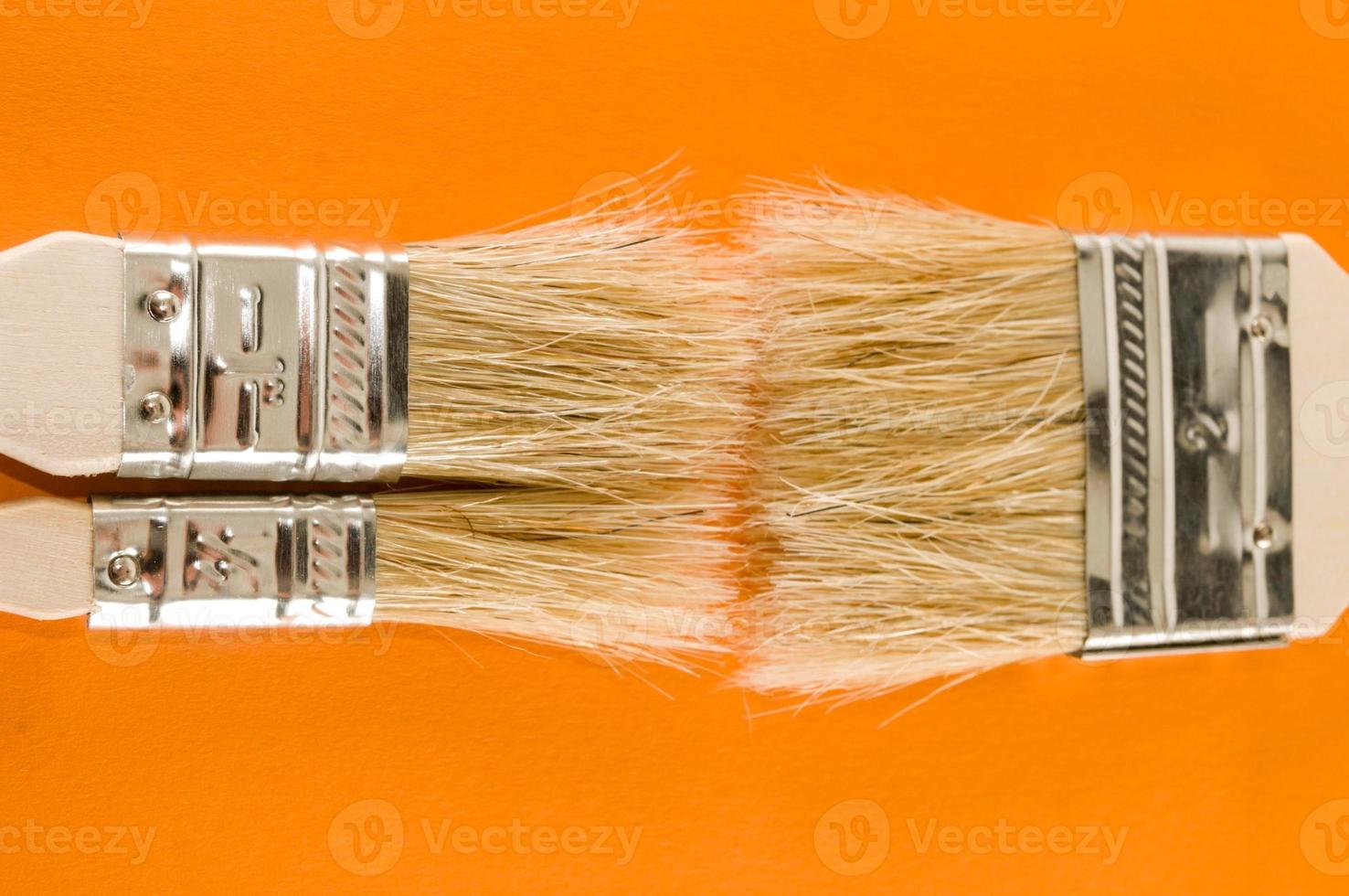 Paint brushes on orange background photo