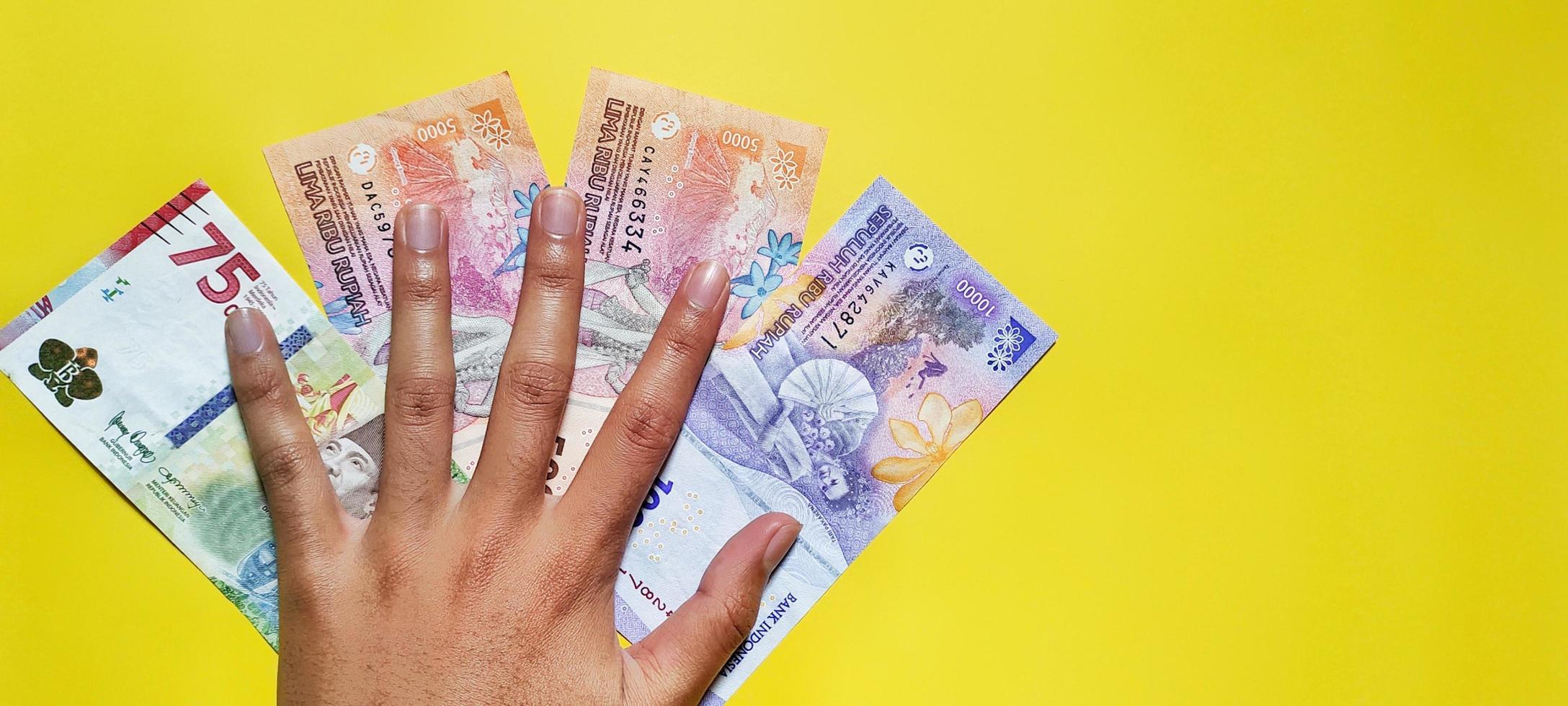 Man holding indonesian rupiah banknotes the latest edition. photo