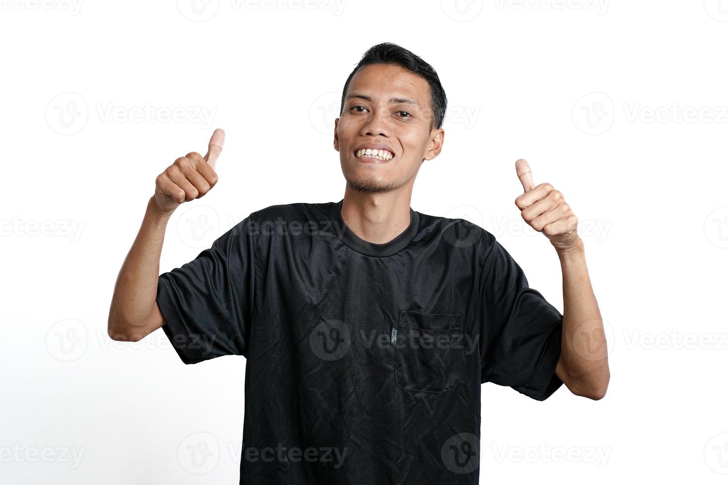 asian man wearing black training t-shirt, feeling happy and giving thumbs up. Isolated by white background photo