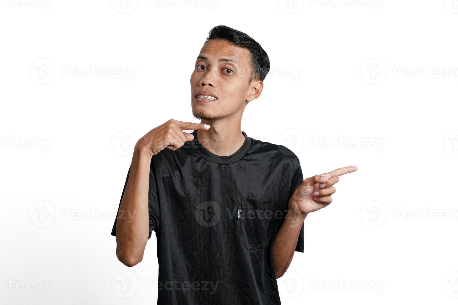 excited asian man wearing black training t-shirt, pointing to copy space. Isolated by white background photo