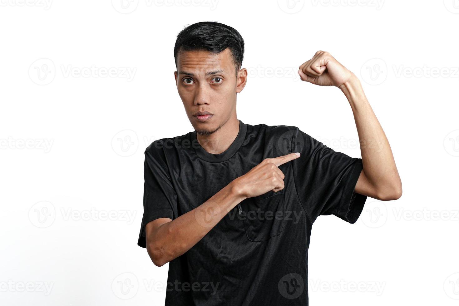 hombre asiático con camiseta negra de entrenamiento, mostrando una postura fuerte con brazos y músculos levantados. aislado por fondo blanco foto