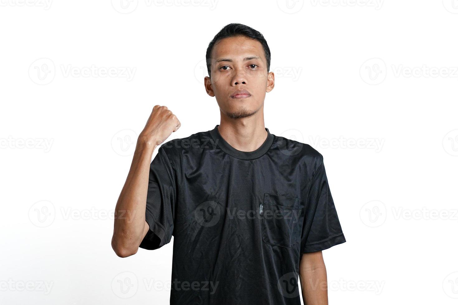 hombre asiático con camiseta negra de entrenamiento, mostrando una postura fuerte con brazos y músculos levantados. aislado por fondo blanco foto