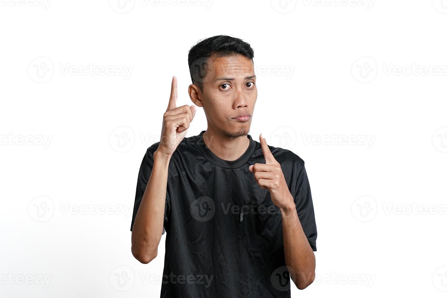 excited asian man wearing black training t-shirt, pointing to copy space. Isolated by white background photo