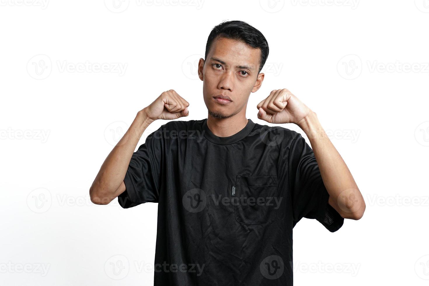 Asian man wearing black training t-shirt, gesturing to fight. Isolated by white background photo