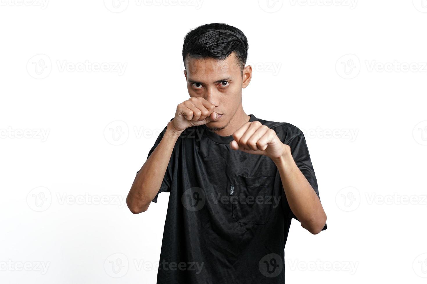 Asian man wearing black training t-shirt, gesturing to fight. Isolated by white background photo