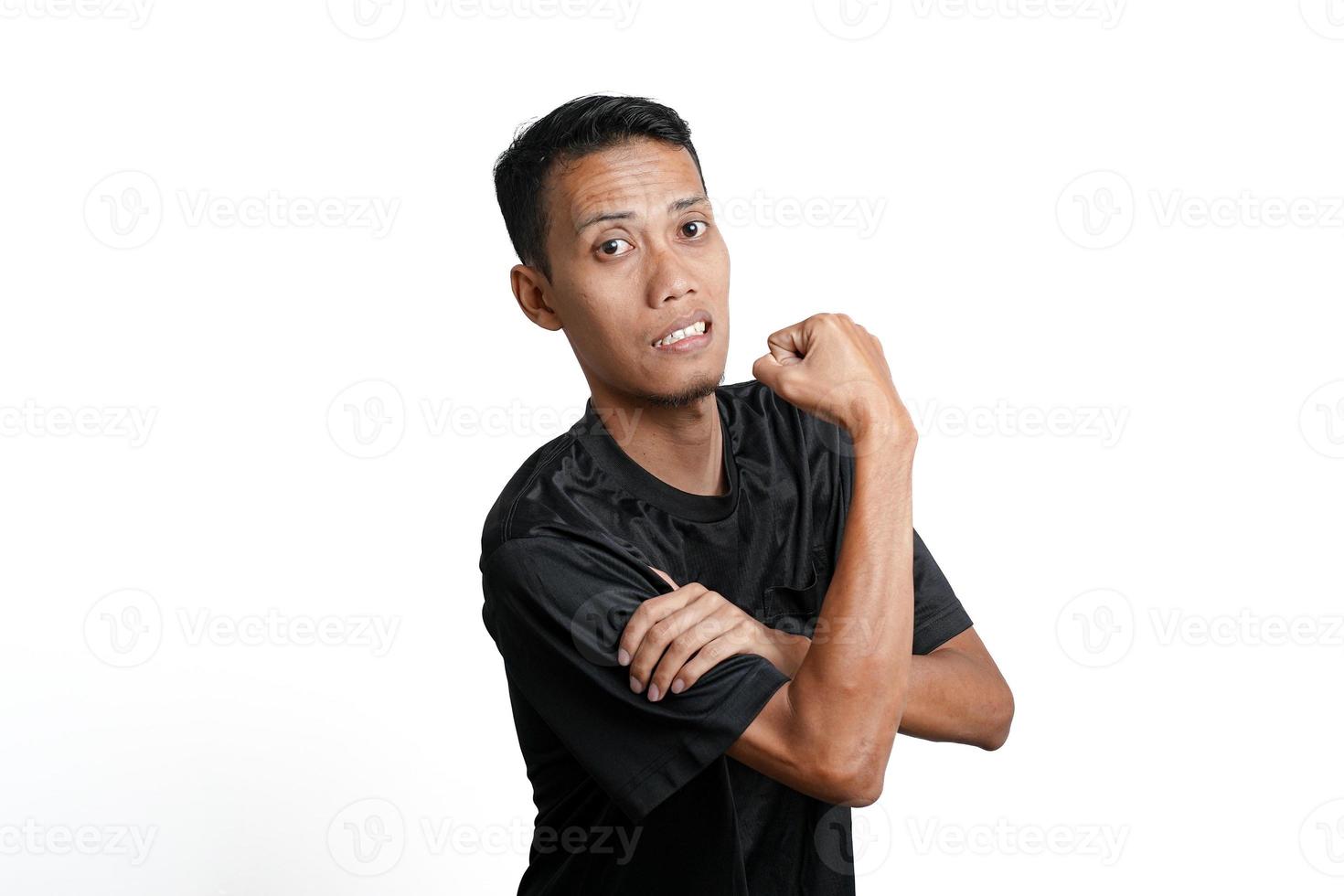 asian man wearing black training t-shirt, showing a strong stance with raised arms and muscles. Isolated by white background photo