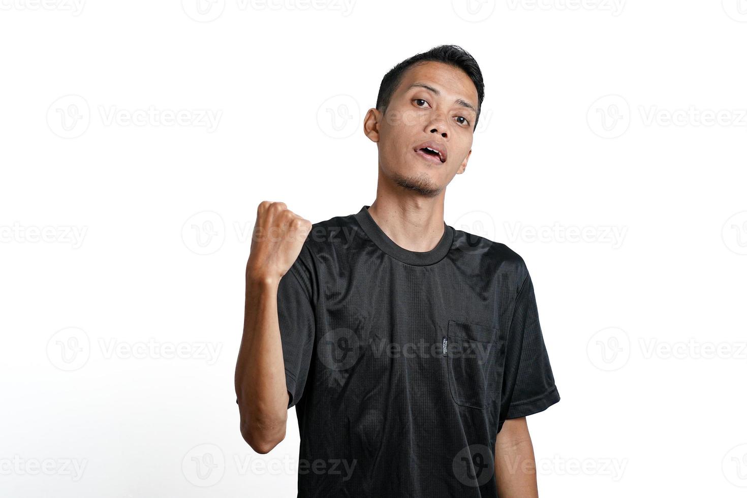 hombre asiático con camiseta negra de entrenamiento, mostrando una postura fuerte con brazos y músculos levantados. aislado por fondo blanco foto