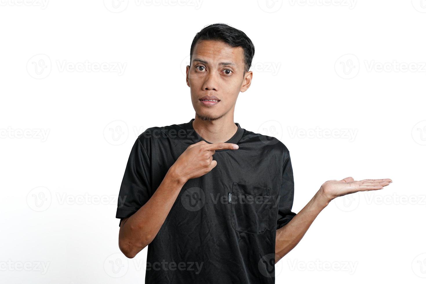 excited asian man wearing black training t-shirt, pointing to copy space. Isolated by white background photo