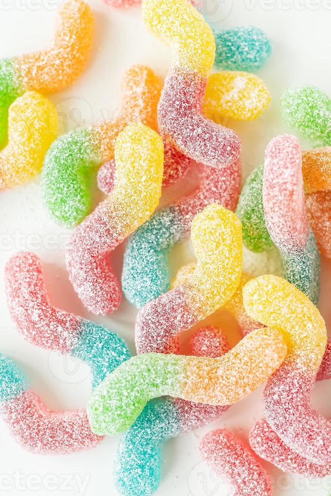 Colorful tasty jelly candies on a white background, top view. Vertical photo. photo