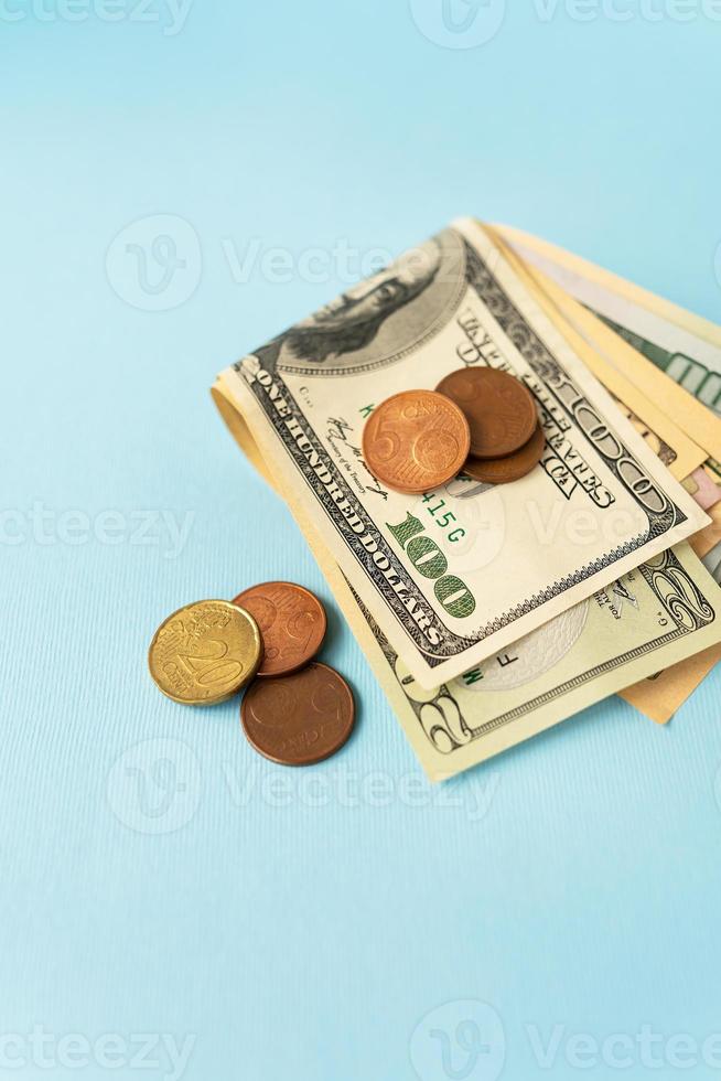 Multicurrency banknotes, euro coins, dollars on a blue background. The concept of the world economy during the crisis. photo
