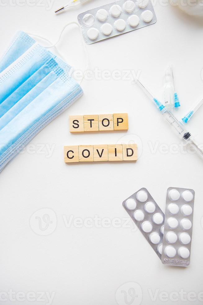 Stop coronavirus inscription. Preparation for vaccination against covid-19. Syringe, vaccine, pills, medical mask. photo