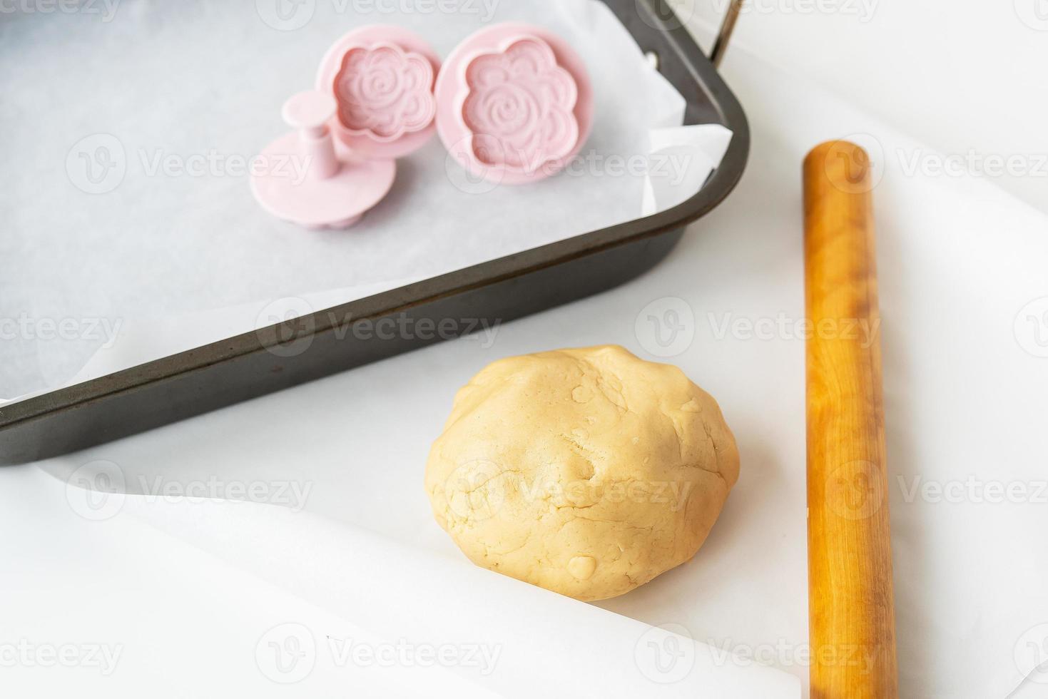 Preparation of dough for making cookies with molds in the form of flowers, a rolling pin and a baking sheet, Concept of cooking food baking at home. photo