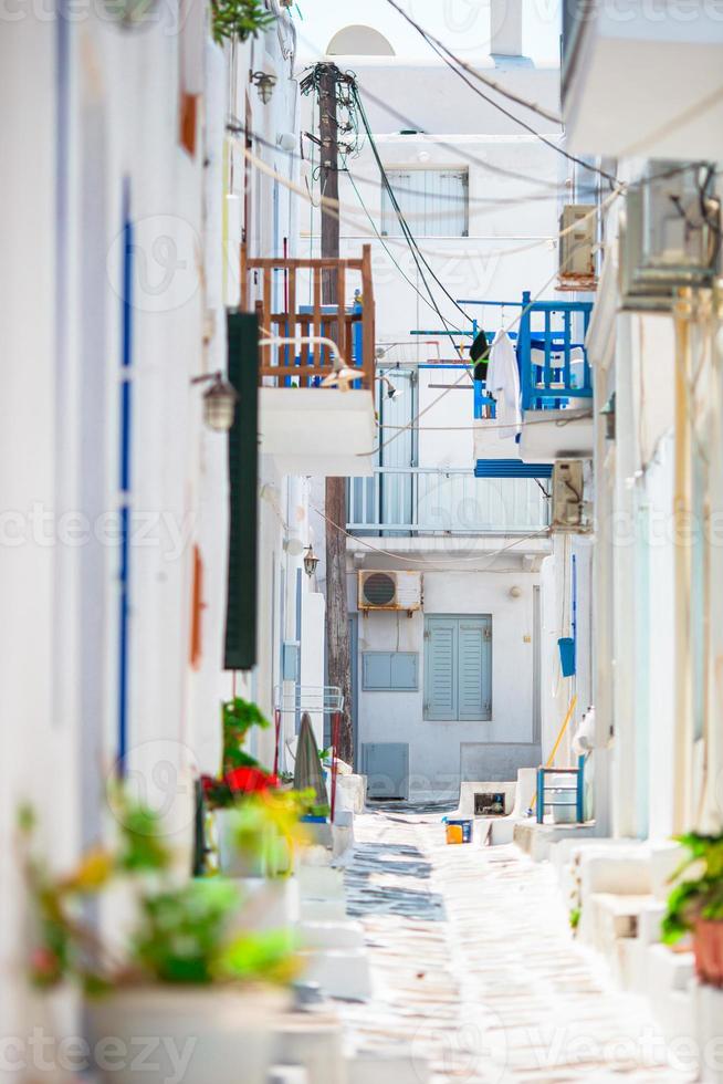 las estrechas calles de la isla griega con balcones azules, escaleras y flores. hermoso edificio de arquitectura exterior con estilo cicládico. foto