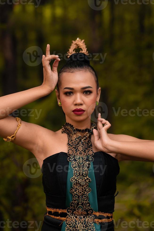 Brave Face of an Asian woman in a traditional green costume with golden accessories on her body during the competition in a dance festival photo