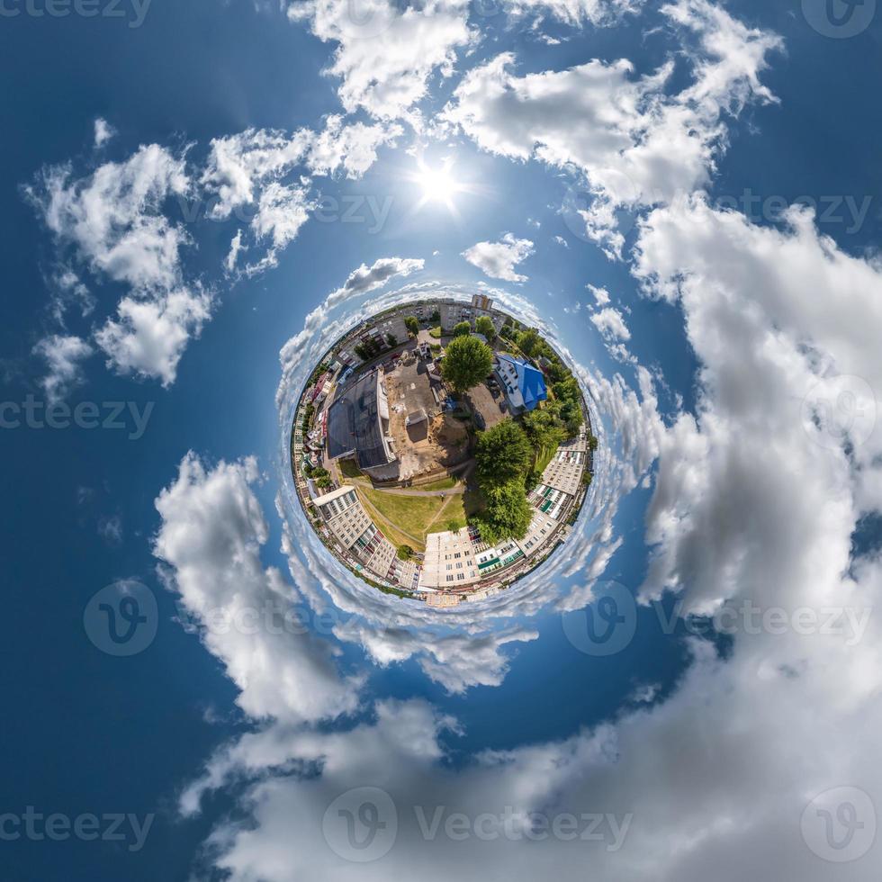 tiny planet in sky with clouds overlooking old town, urban development, historic buildings and crossroads. Transformation of spherical 360 panorama in abstract aerial view. photo