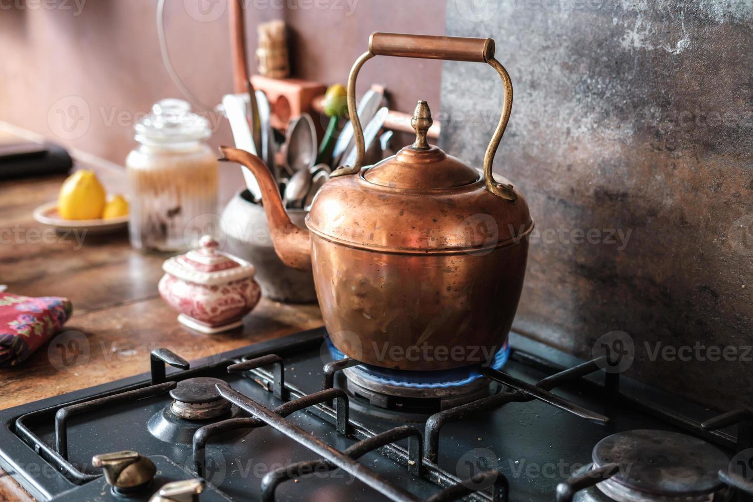 Tetera vintage de cobre en la estufa de gas en la cocina moderna foto