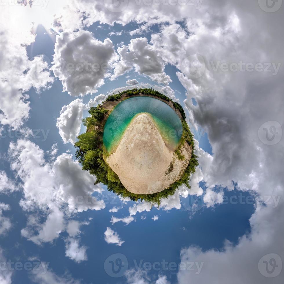 green tiny planet in blue sky with beautiful clouds. Transformation of spherical panorama 360 degrees. Spherical abstract aerial view. Curvature of space. photo