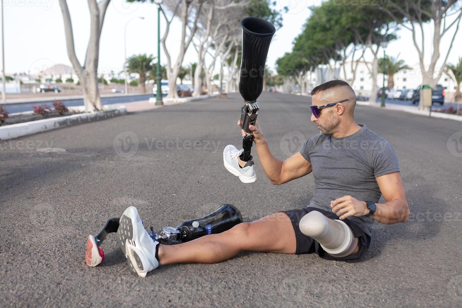 Male runner changing leg prosthesis before training photo