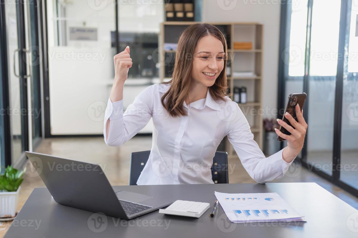 Marketing, Finance, Accounting, Planning. Caucasian businesswoman holding mobile phone and showing goodwill in customer joining business with company to increase profit of laptop office and documents photo
