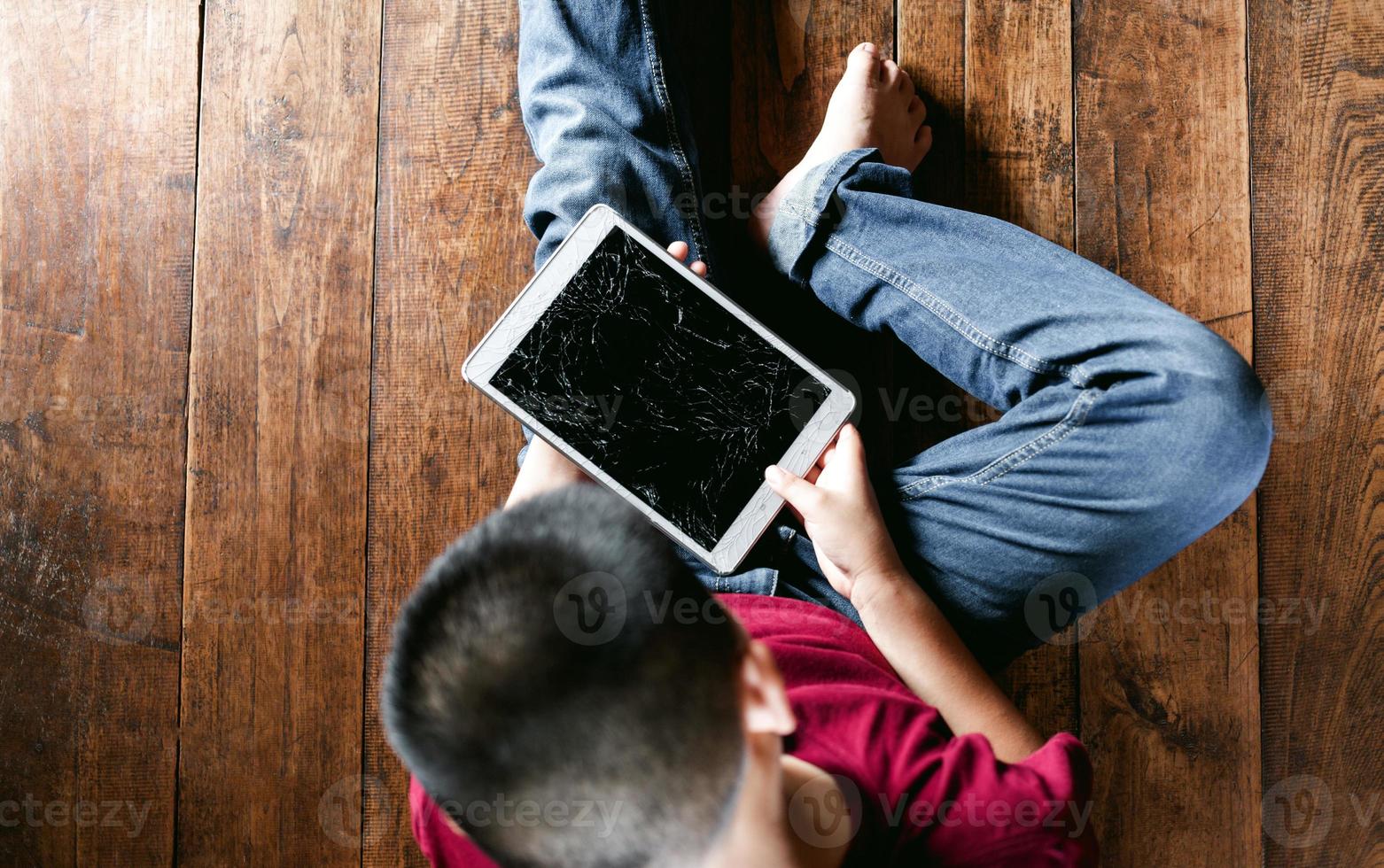 Portrait of a little Asian boy, Kid sad face, Unhappy child sitting holding  broken tablet computer, Emotion sad and sad face, depressed children concept photo