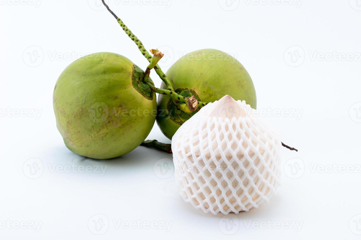 Coconut peeled in a diamond shape and green coconut background. photo