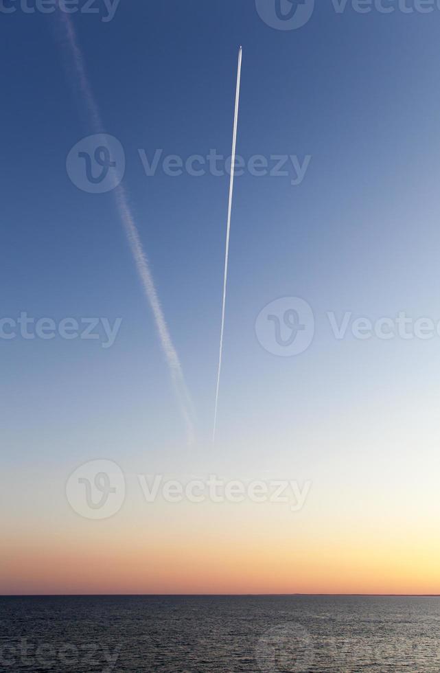 The Sky With A Flying Airplane At Dusk photo