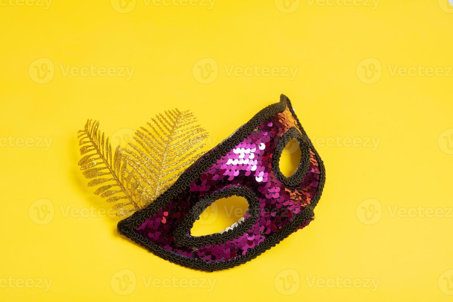 Festive face mask for carnival or masquerade celebration on colored background photo